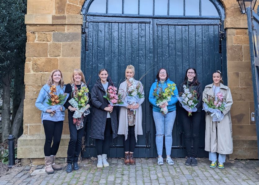 floristry course participants holding arrangements