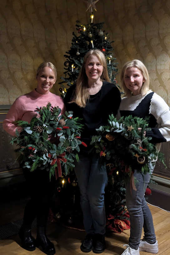Holding Christmas Wreaths by the Tree
