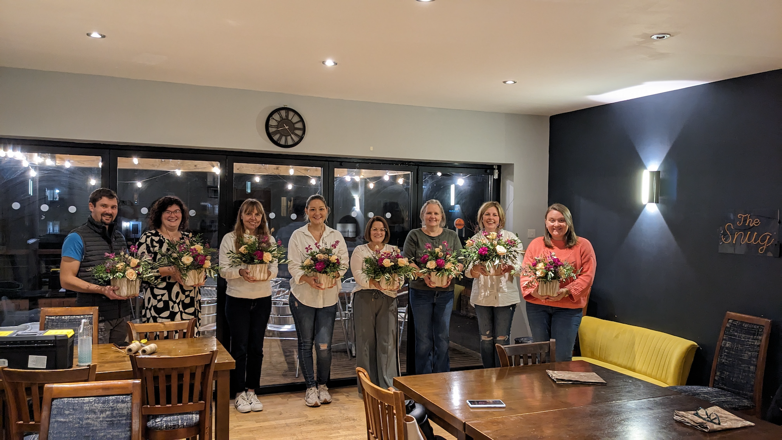 floristry course participants holding arrangements