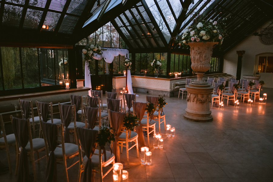 candles in vases lining the aisle at twilight